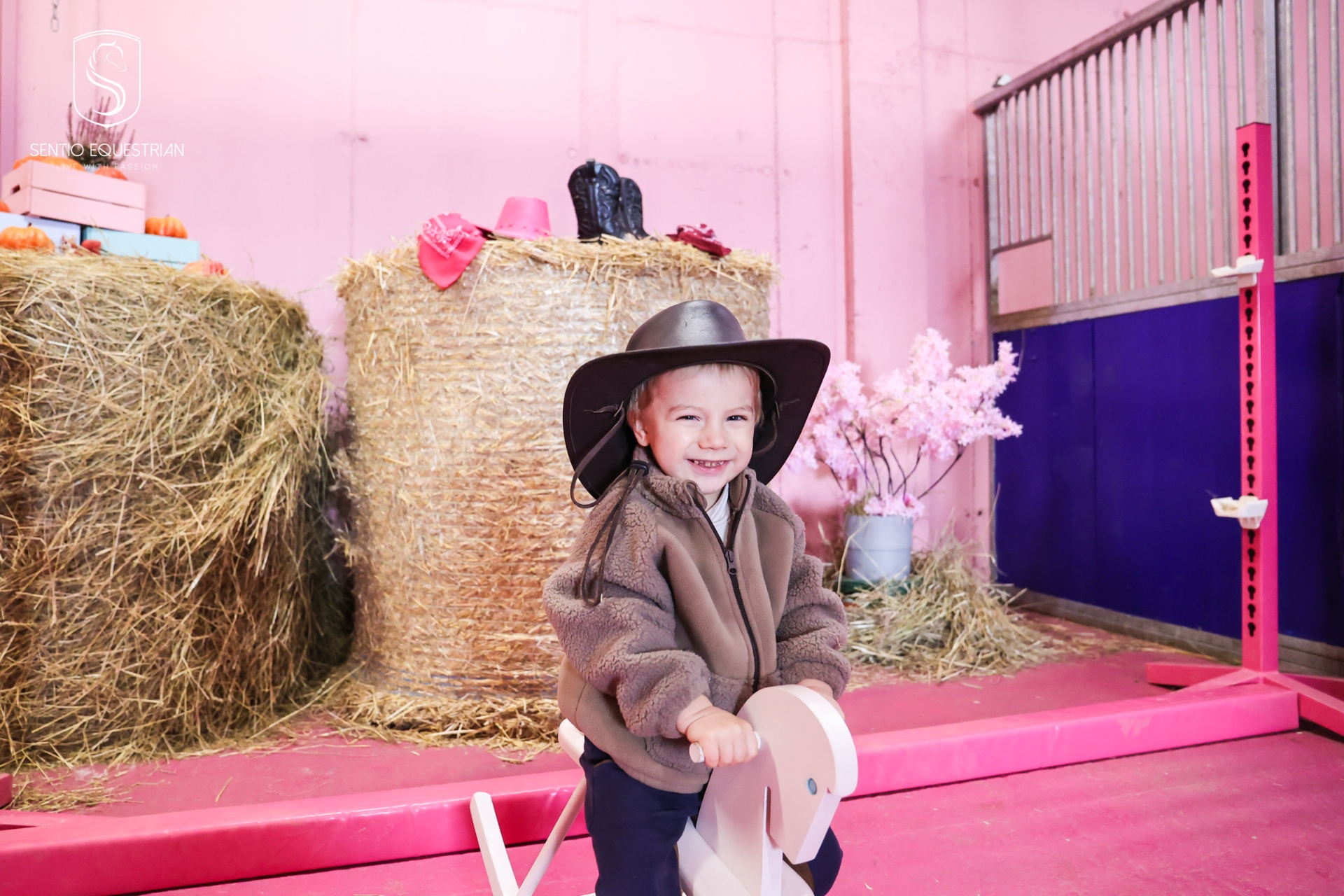 Roześmiane dziecko w kapeluszu na koniu na biegunach