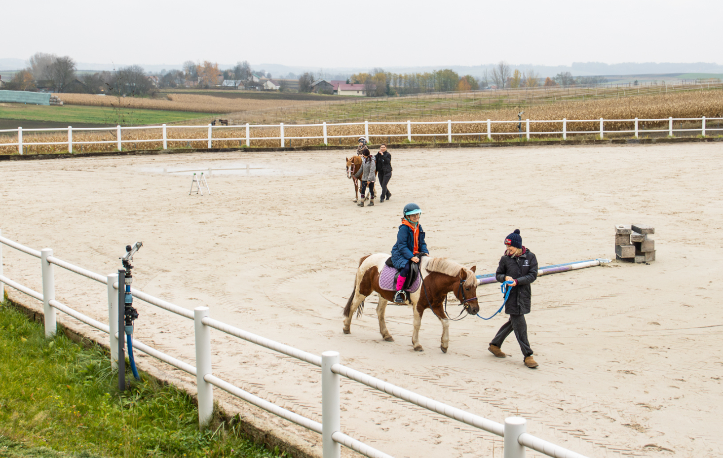 Dziecko na kucyku z instruktorem na placu — jazdy indywidualne
